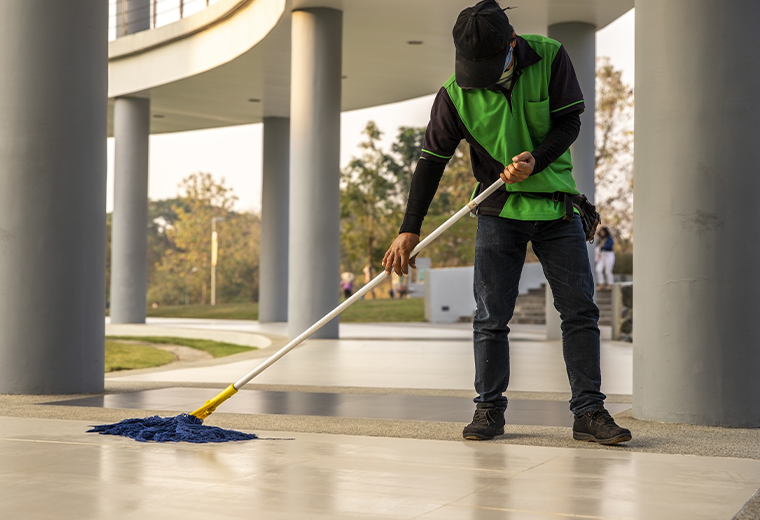 A  janitor man  cleaning  mopping floor in office building or walkway modern building
